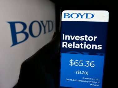 Stuttgart, Almanya - 10-17-2024: ABD 'li konukseverlik şirketi Boyd Gaming Corporation' ın internet sayfası ile cep telefonu tutan kişi logolu ekranda. Telefon ekranının merkezine odaklan.