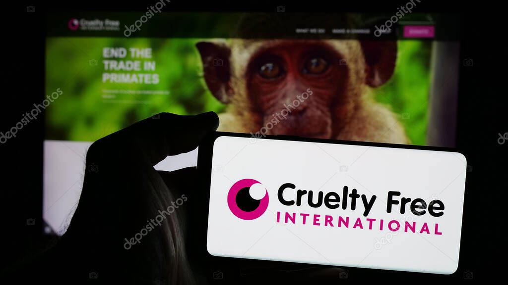 Stuttgart, Germany - 10-11-2024: Person holding mobile phone with logo of organization Cruelty Free International on screen in front of web page. Focus on phone display.