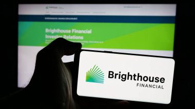 Stuttgart, Almanya - 10-17-2024: ABD 'li sigorta şirketi Brighthouse Financial Inc.' in logosunu elinde tutan kişi web sitesinin önünde ekranda. Telefon ekranına odaklan.
