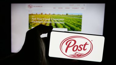 Stuttgart, Almanya - 10-17-2024: İnternet sitesi önünde ekranda ABD 'li tüketici malları şirketi Post Holdings Inc.' in logosunu taşıyan akıllı telefon sahibi kişi. Telefon ekranına odaklan.