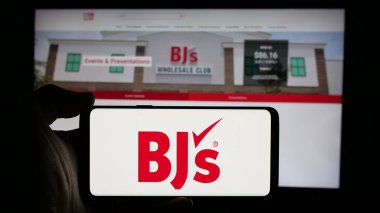 Stuttgart, Almanya - 10-17-2024: Web sayfası önünde ekranda BJ 'in Toptan Kulüp Holding Inc.' sinin logosunun bulunduğu cep telefonu sahibi kişi. Telefon ekranına odaklan.