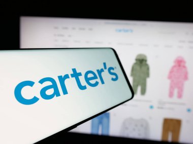 Stuttgart, Almanya - 10-18-2024: Web sitesinin önünde ekranda Amerikalı çocuk giyim şirketinin logosu olan cep telefonu. Telefon ekranının merkez soluna odaklan.