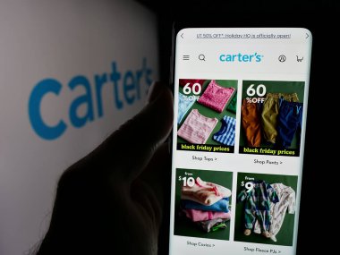 Stuttgart, Almanya - 10-18-2024: ABD 'li çocuk giyim şirketi Carter' s Inc. 'in web sayfası olan akıllı telefon sahibi kişi logonun önünde ekranda. Telefon ekranının merkezine odaklan.