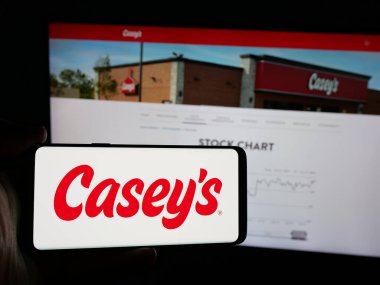 Stuttgart, Almanya - 10-18-2024: İnternet sitesi önünde ekranda Casey 's General Stores Inc.' in logosunun bulunduğu akıllı telefon sahibi kişi. Telefon ekranına odaklan.