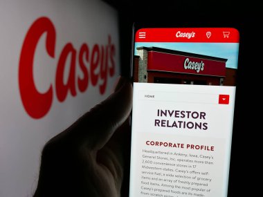 Stuttgart, Almanya - 10-18-2024: ABD 'li firma Casey' s General Stores Inc. 'in internet sayfası ile cep telefonu tutan kişi logonun önünde ekranda. Telefon ekranının merkezine odaklan.