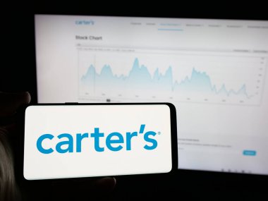 Stuttgart, Almanya - 10-18-2024: Üzerinde Amerikalı çocuk giyim şirketi Carter 'ın logosu olan cep telefonu sahibi kişi web sayfasının önünde ekranda. Telefon ekranına odaklan.