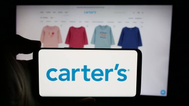 Stuttgart, Almanya - 10-18-2024: ABD 'li çocuk giyim şirketi Carter' s Inc. 'in logosu olan cep telefonu sahibi kişi iş sayfasının önünde ekranda. Telefon ekranına odaklan.