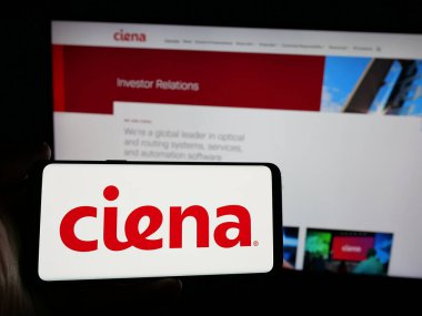 Stuttgart, Almanya - 10-18-2024: ABD 'li ağ sistemi şirketi Ciena Corporation' ın logosuyla akıllı telefon sahibi kişi web sitesinin önünde ekranda. Telefon ekranına odaklan.