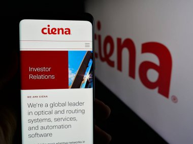 Stuttgart, Almanya - 10-18-2024: ABD 'li ağ sistemi şirketi Ciena Corporation' ın internet sayfası ile cep telefonu tutan kişi logolu ekranda. Telefon ekranının merkezine odaklan.