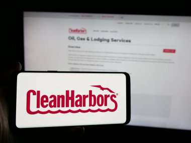 Stuttgart, Almanya - 10-18-2024: ABD hizmet şirketi Clean Harbors Inc. 'in logosunun bulunduğu akıllı telefonu web sitesinin önünde tutan kişi. Telefon ekranına odaklan.