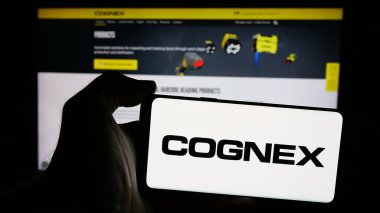 Stuttgart, Almanya - 10-18-2024: Web sitesinin önünde ekranda ABD 'li makine vizyon şirketi Cognex Corporation' ın logosunu taşıyan kişi. Telefon ekranına odaklan.