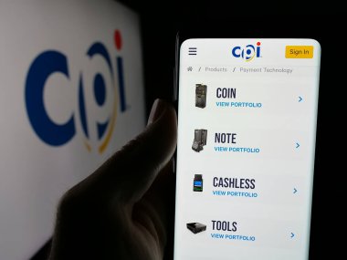 Stuttgart, Almanya - 10-18-2024: ABD 'li Crane Payment Innovations Inc. (CPI) şirketinin web sayfası ile akıllı telefon sahibi kişi ekranda logolu. Telefon ekranının merkezine odaklan.