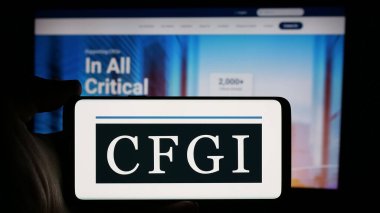Stuttgart, Almanya - 10-18-2024: ABD 'li danışmanlık şirketi CFGI' nin logosuyla cep telefonu sahibi kişi iş sayfasının önünde ekranda. Telefon ekranına odaklan.