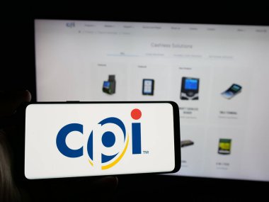 Stuttgart, Almanya - 10-18-2024: İnternet sitesi önünde üzerinde Crane Payment Innovations Inc. (CPI) logosu bulunan kişi. Telefon ekranına odaklan.