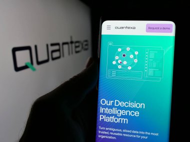Stuttgart, Almanya - 10-21-2024: İngiliz veri analiz şirketi Quantexa Limited 'in web sayfası ile akıllı telefon sahibi kişi logo ile ekranda. Telefon ekranının merkezine odaklan.