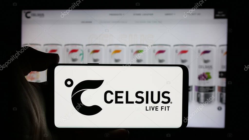 Stuttgart, Germany - 10-18-2024: Person holding cellphone with logo of US beverage company Celsius Holdings Inc. on screen in front of business webpage. Focus on phone display.