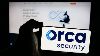 Stuttgart, Almanya - 10-22-2024: Amerikan Orca Security Ltd. şirketinin logosunun bulunduğu cep telefonu sahibi kişi iş sayfasının önünde ekranda. Telefon ekranına odaklan.