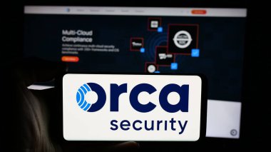 Stuttgart, Almanya - 10-22-2024: ABD 'li Orca Security Ltd. şirketinin logosuyla cep telefonu sahibi kişi iş sayfasının önünde ekranda. Telefon ekranına odaklan.