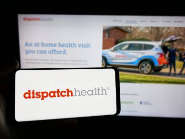 Stuttgart, Almanya - 10-22-2024: ABD 'li DispatchHealth Management LLC logosuna sahip kişi web sitesi önünde ekranda. Telefon ekranına odaklan.