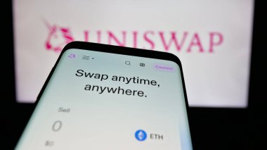 Stuttgart, Almanya - 10-23-2024: Kripto döviz şirketi Uniswap Labs 'in web sitesi ile birlikte iş logosu önünde cep telefonu. Telefon ekranının sol üst kısmına odaklan.