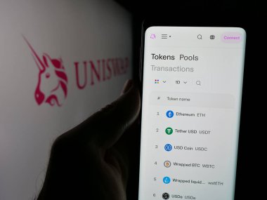 Stuttgart, Almanya - 10-23-2024: Şifreleme değişim şirketi Uniswap Labs 'in web sayfası olan akıllı telefonu ekranda logolu kişi. Telefon ekranının merkezine odaklan.