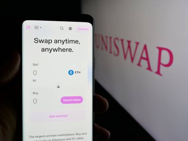 Stuttgart, Almanya - 10-23-2024: Kripto döviz şirketi Uniswap Labs 'in web sayfası olan cep telefonlu kişi logolu ekranda. Telefon ekranının merkezine odaklan.