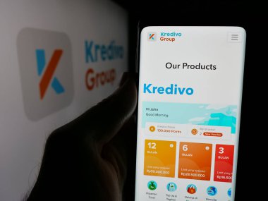 Stuttgart, Almanya - 10-23-2024: Endonezyalı fintech şirketi Kredivo Group 'un web sayfası ile logo önünde cep telefonu tutan kişi. Telefon ekranının merkezine odaklan.