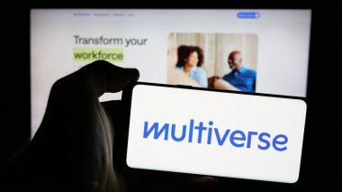 Stuttgart, Almanya - 10-23-2024: İngiliz Multiverse Group Ltd. logosu olan cep telefonu sahibi kişi iş sayfasının önünde ekranda. Telefon ekranına odaklan.