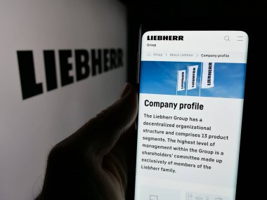 Stuttgart, Almanya - 10-24-2024: İsviçreli Liebherr Group şirketinin web sayfası ile cep telefonu sahibi kişi iş logosu önünde ekranda. Telefon ekranının merkezine odaklan.