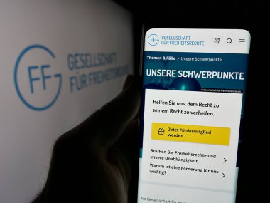 Stuttgart, Almanya - 10-24-2024: Gesellschaft fuer Freiheitsrechte E.V. web sayfası ile akıllı telefon tutan kişi Ekranda logo var. Telefon ekranının merkezine odaklan.