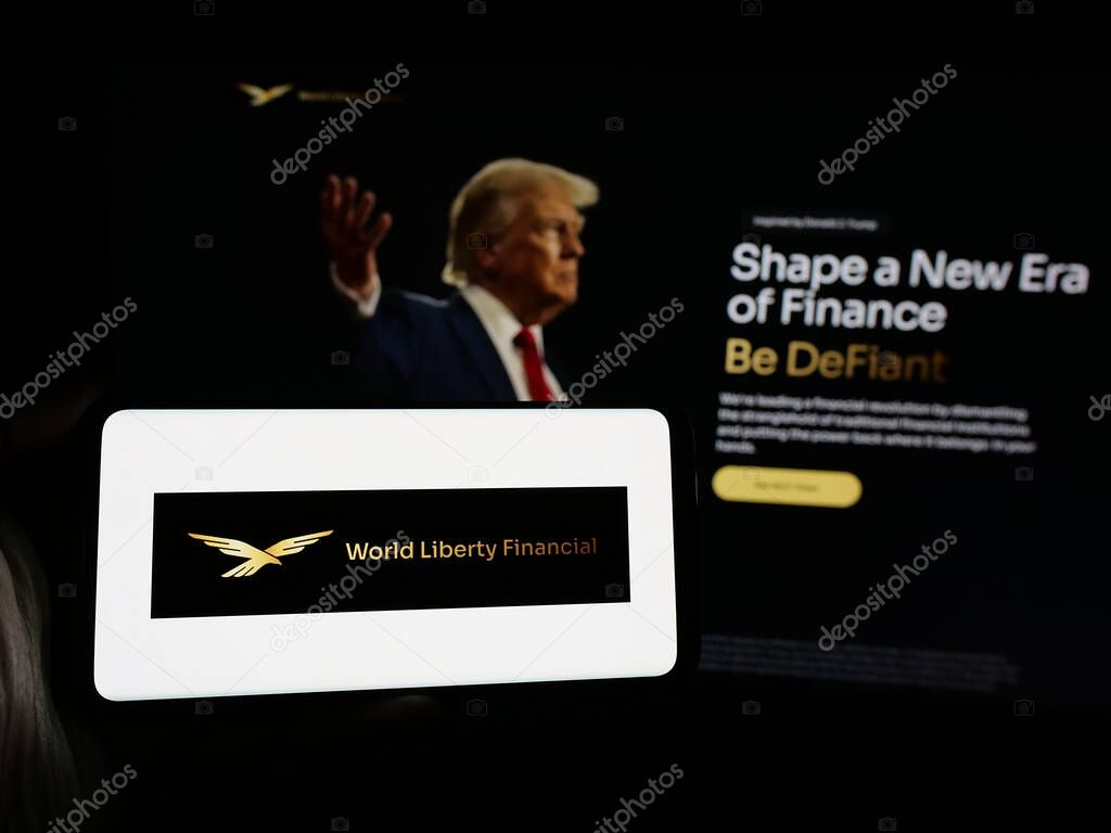 Stuttgart, Germany - 10-22-2024: Person holding smartphone with logo of US crypto company World Liberty Financial Inc. on screen in front of website. Focus on phone display.