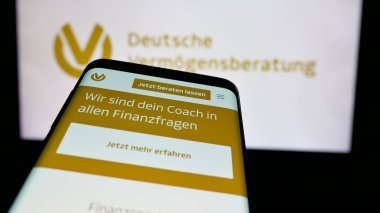 Stuttgart, Almanya - 10-25-2024: İş logosu önünde ekranda Deutsche Vermoegensberatung AG (DVAG) şirketinin web sitesi bulunan cep telefonu. Telefon ekranının sol üst kısmına odaklan.