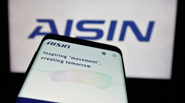 Stuttgart, Almanya - 10-25-2024: Japon otomotiv şirketi Aisin Corporation 'ın web sitesi ile birlikte logo önünde ekranda. Telefon ekranının sol üst kısmına odaklan.