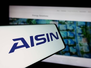 Stuttgart, Almanya - 10-25-2024: Japon otomotiv şirketi Aisin Corporation 'ın logosuna sahip akıllı telefon web sitesinin önünde ekranda. Telefon ekranının merkez soluna odaklan.