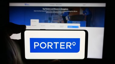 Stuttgart, Almanya - 10-28-2024: Üzerinde Hint lojistik şirketi Porter 'ın logosu olan cep telefonu sahibi kişi iş sayfasının önünde ekranda. Telefon ekranına odaklan.