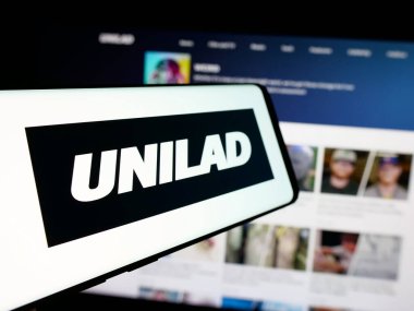 Stuttgart, Almanya - 10-28-2024: İngiliz çevrimiçi medya şirketi UNILAD 'ın logosuna sahip akıllı telefon iş dünyasının web sitesi önünde ekranda. Telefon ekranının soluna odaklan.