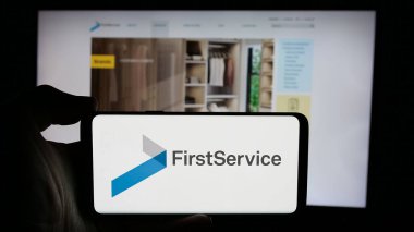Stuttgart, Almanya - 10-30-2024: Kanadalı firma Firması 'nın logosuyla cep telefonu sahibi kişi iş sayfasının önünde ekranda. Telefon ekranına odaklan.