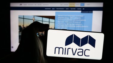 Stuttgart, Almanya - 10-30-2024: Avustralyalı emlak şirketi Mirvac Group 'un logosunu elinde tutan kişi web sitesinin önünde ekranda. Telefon ekranına odaklan.