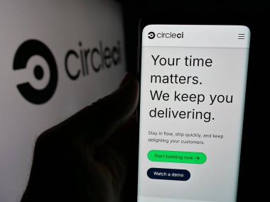 Stuttgart, Almanya - 10-30-2024: Logonun önündeki ekranda Circle Internet Services Inc. (CircleCI) web sayfası olan cep telefonu sahibi. Telefon ekranının merkezine odaklan.