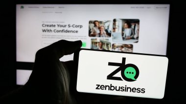 Stuttgart, Almanya - 10-31-2024: Amerikan ZenBusiness Inc. şirketinin logosunun bulunduğu cep telefonu sahibi kişi iş sayfasının önünde ekranda. Telefon ekranına odaklan.
