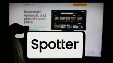 Stuttgart, Almanya - 10-31-2024: İş sayfası önünde ekranda ABD 'li platform şirketi Spotter Inc.' in logosuyla cep telefonu tutan kişi. Telefon ekranına odaklan.