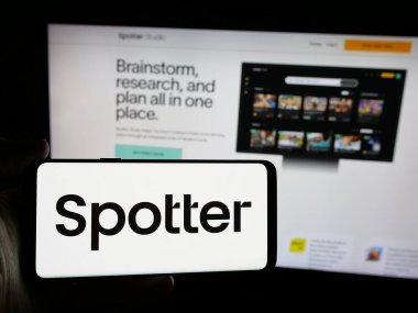 Stuttgart, Almanya - 10-31-2024: Web sayfasının önünde ekranda Amerikan platform şirketi Spotter Inc. 'in logosunun bulunduğu cep telefonu sahibi kişi. Telefon ekranına odaklan.