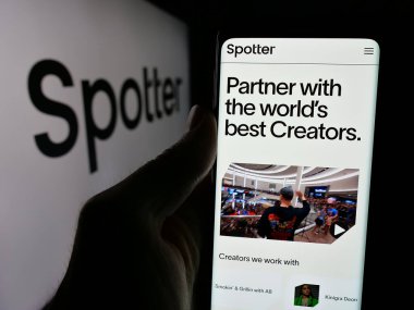 Stuttgart, Almanya - 10-31-2024: ABD 'li platform şirketi Spotter Inc.' in web sayfası ile akıllı telefon sahibi kişi logonun önünde ekranda. Telefon ekranının merkezine odaklan.