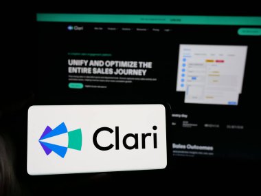 Stuttgart, Almanya - 10-31-2024: İnternet sitesinin önünde ekranda ABD 'li gelir platformu şirketi Clari Inc.' in logosuna sahip akıllı telefonu tutan kişi. Telefon ekranına odaklan.