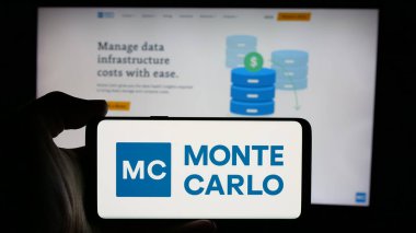 Stuttgart, Almanya - 10-31-2024: ABD 'li veri gözlem şirketi Monte Carlo Inc.' nin logosunun bulunduğu cep telefonu sahibi kişi iş sayfasının önünde ekranda. Telefon ekranına odaklan.