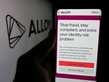 Stuttgart, Almanya - 10-31-2024: Kimlik risk şirketi First Mile Group Inc. 'in (Alloy) web sayfası bulunan cep telefonu logolu kişi. Telefon ekranının merkezine odaklan.