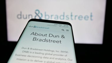 Stuttgart, Almanya - 11-06-2024: ABD 'li veri şirketi Dun ve Bradstreet Holding Inc.' nin web sitesiyle birlikte cep telefonu logonun önünde ekranda. Telefon ekranının sol üst kısmına odaklan.