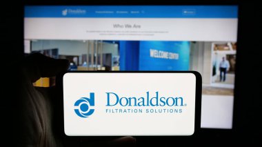Stuttgart, Almanya - 11-06-2024: ABD filtreleme şirketi Donaldson Company Inc. 'in logosuyla cep telefonu sahibi kişi iş sayfasının önünde ekranda. Telefon ekranına odaklan.
