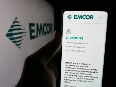 Stuttgart, Almanya - 11-07-2024: ABD 'li mühendislik şirketi EMCOR Group Inc.' nin web sitesi olan cep telefonu logosu önünde ekranda. Telefon ekranının merkezine odaklan. 