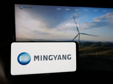 Stuttgart, Almanya - 11-07-2024: Çinli şirket Ming Yang Wind Power Group Limited 'in logosuna sahip akıllı telefon sahibi kişi web sitesi önünde ekranda. Telefon ekranına odaklan.